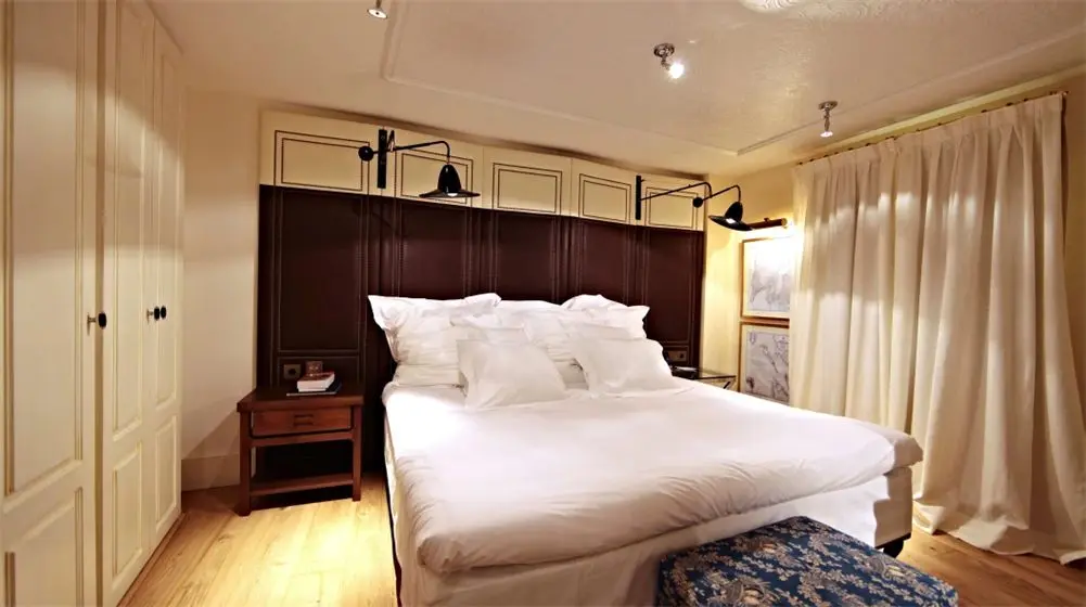 Hotel room with a dark headboard and white bed linen