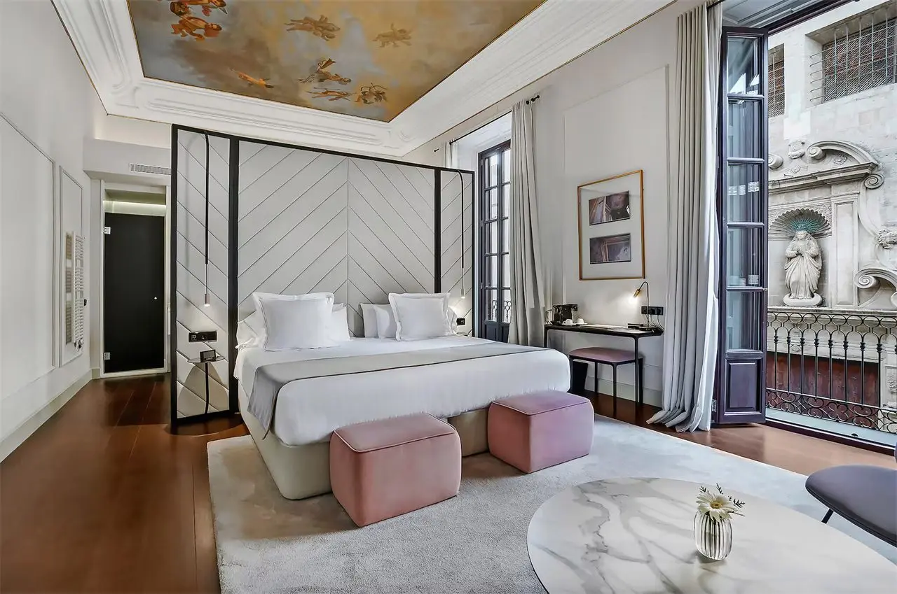 Hotel suite with a painted ceiling and a white bed