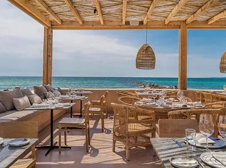 Restaurant terrace with tables laid, facing the sea